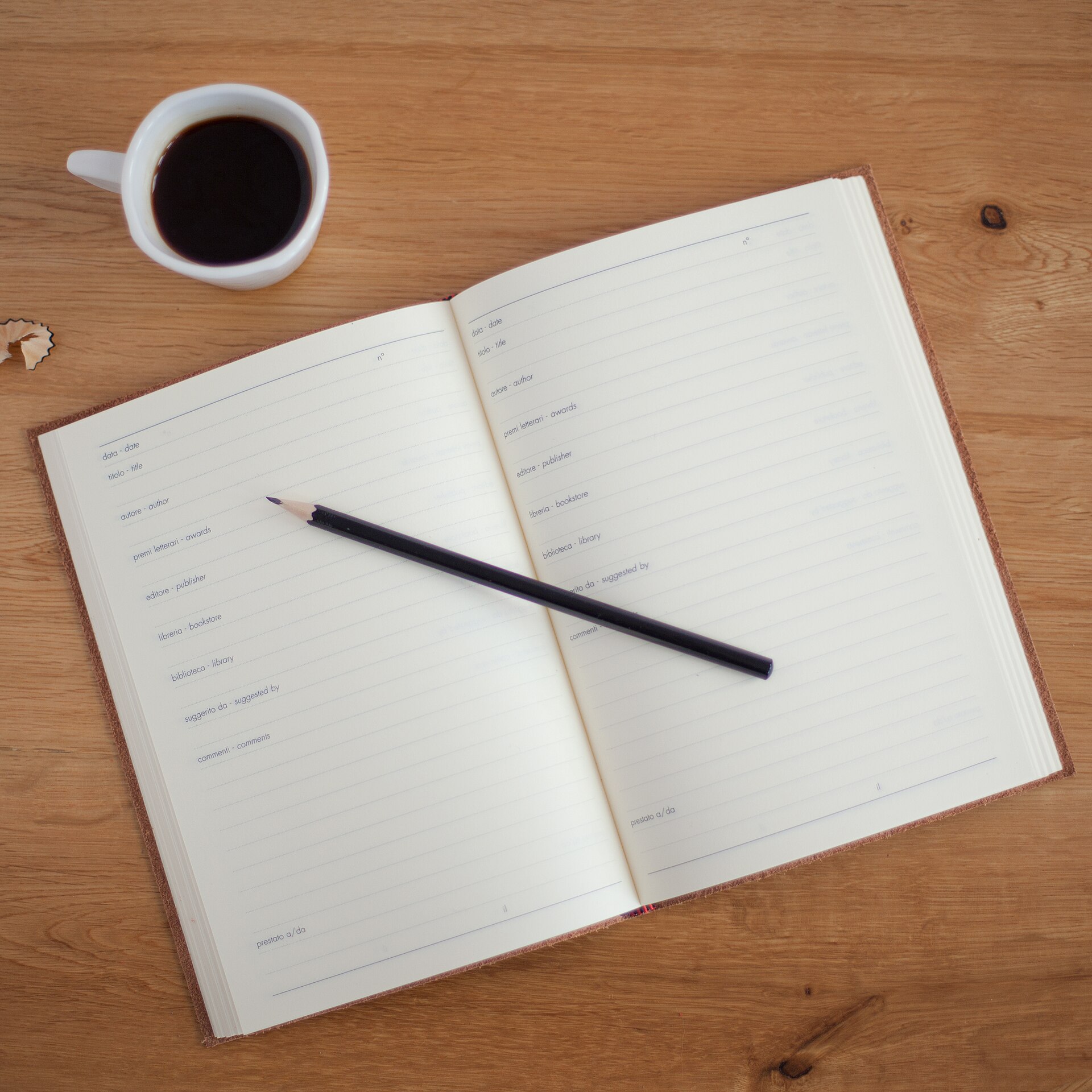 An open planner and pen beside coffee
