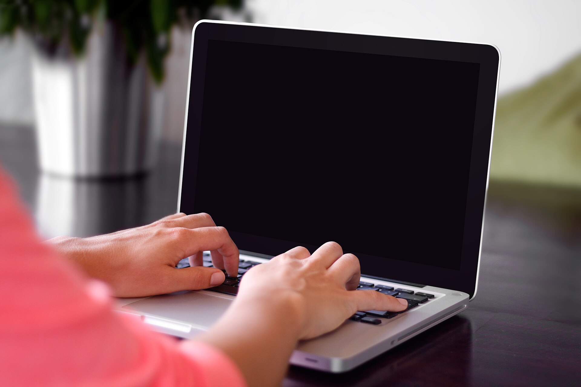 Hands typing on a laptop
