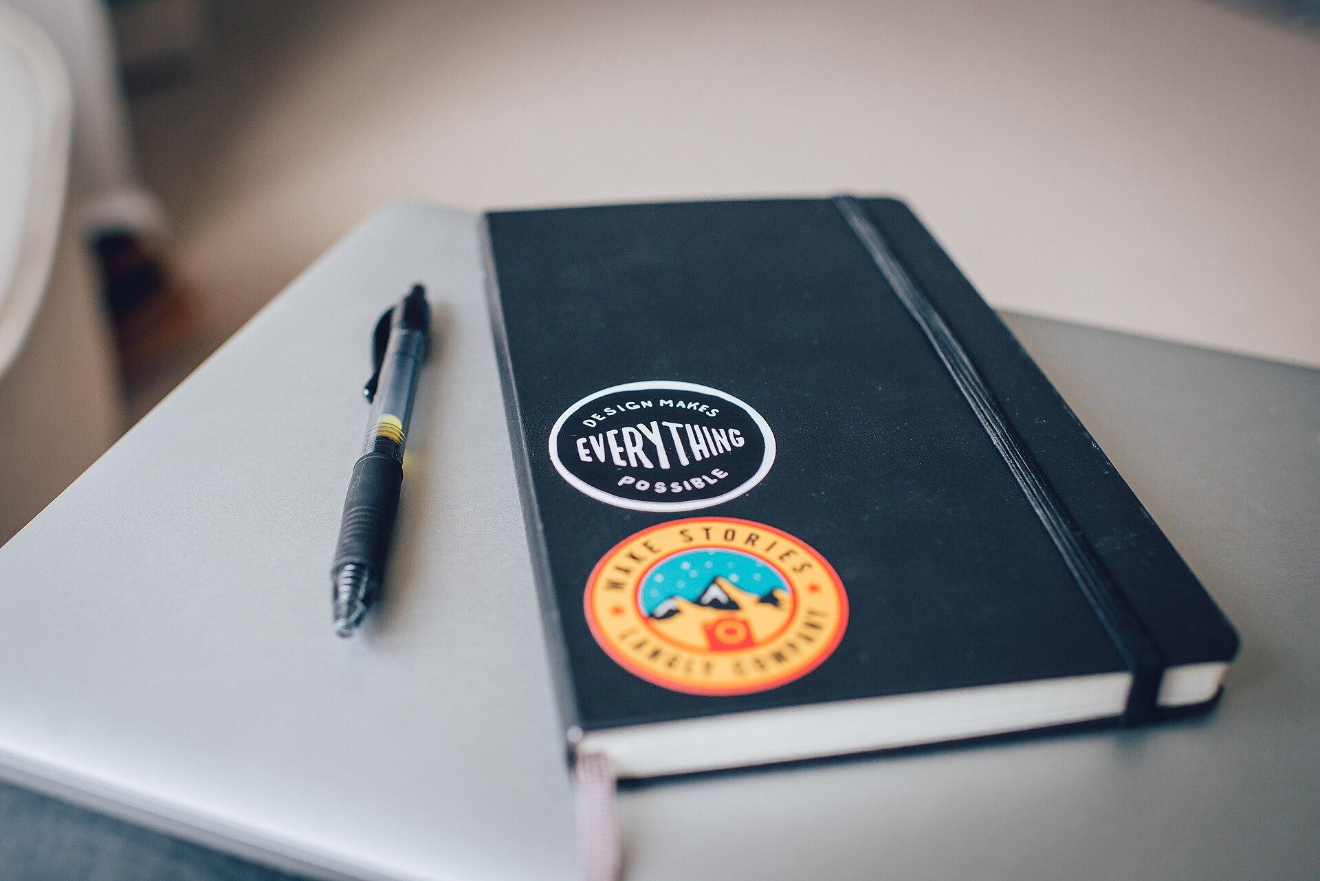 A notebook and pen resting on a laptop