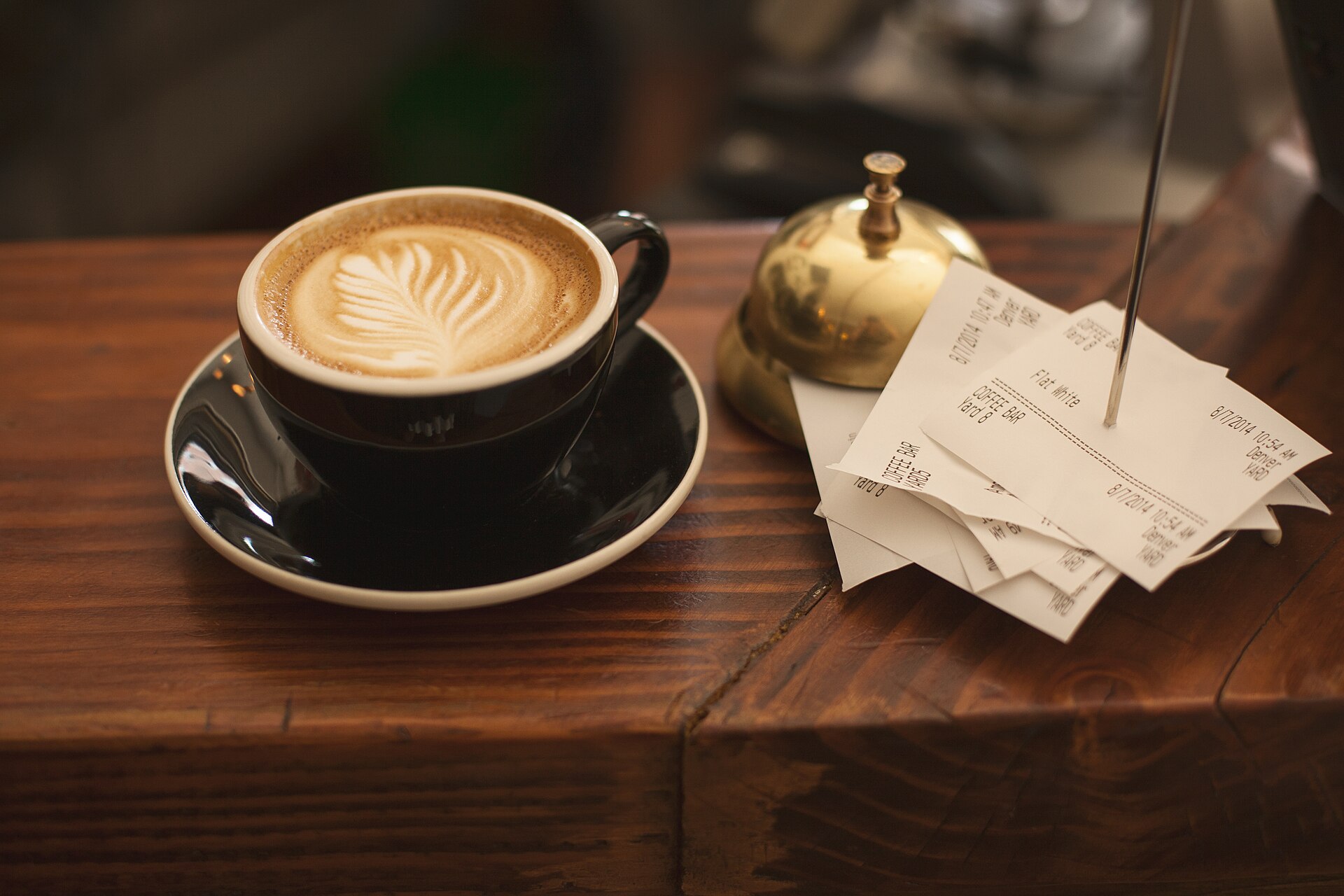 Coffee beside a small stack of receipts
