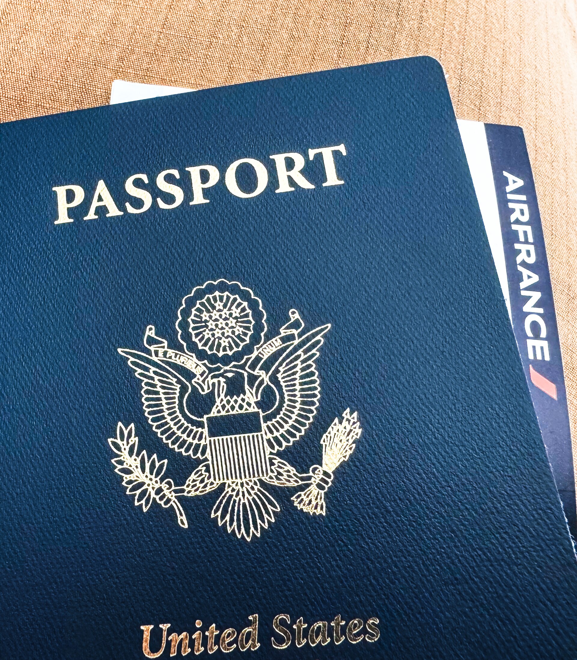 A closed passport beside a boarding pass
