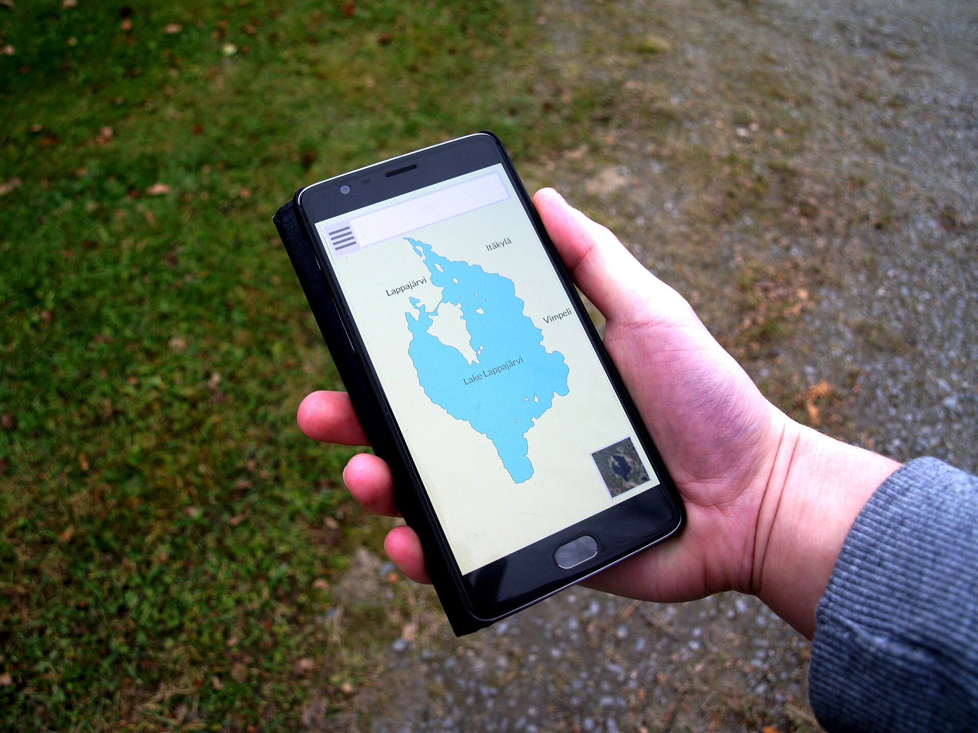 A hand holding a smartphone with a navigation map